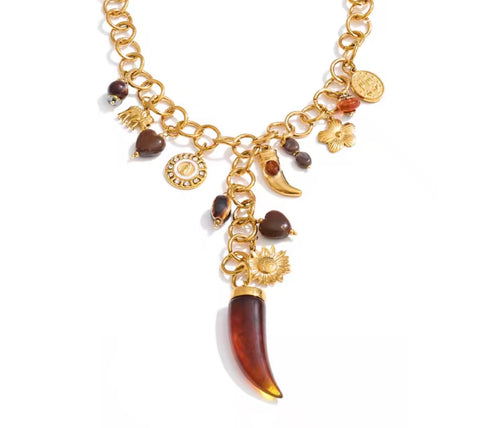 Collana charm con pendente corno e dettagli caldi.
Un gioiello ricco di fascino e significato, caratterizzato da una catena importante arricchita da charms simbolici e tonalità calde che ricordano la terra e il sole.

Il protagonista è il pendente a corno, simbolo di protezione e fortuna, accompagnato da cuori, fiori e piccoli dettagli luminosi che rendono questa collana unica e piena di personalità.