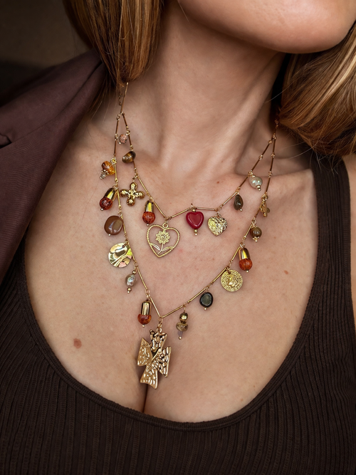 Collana multilayer con charms e dettagli colorati.
Un gioiello ricco di personalità che non passa inosservato: doppia catena con pendenti mixati tra simboli, perle e dettagli colorati per un effetto unico e super stiloso.

Perfetta per dare carattere anche agli outfit più semplici, aggiungendo subito un tocco boho-chic e ricercato.