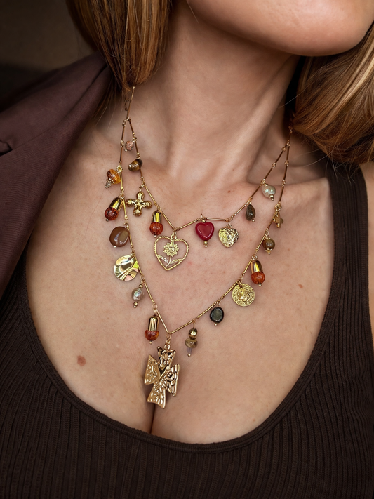 Collana multilayer con charms e dettagli colorati.
Un gioiello ricco di personalità che non passa inosservato: doppia catena con pendenti mixati tra simboli, perle e dettagli colorati per un effetto unico e super stiloso.

Perfetta per dare carattere anche agli outfit più semplici, aggiungendo subito un tocco boho-chic e ricercato.