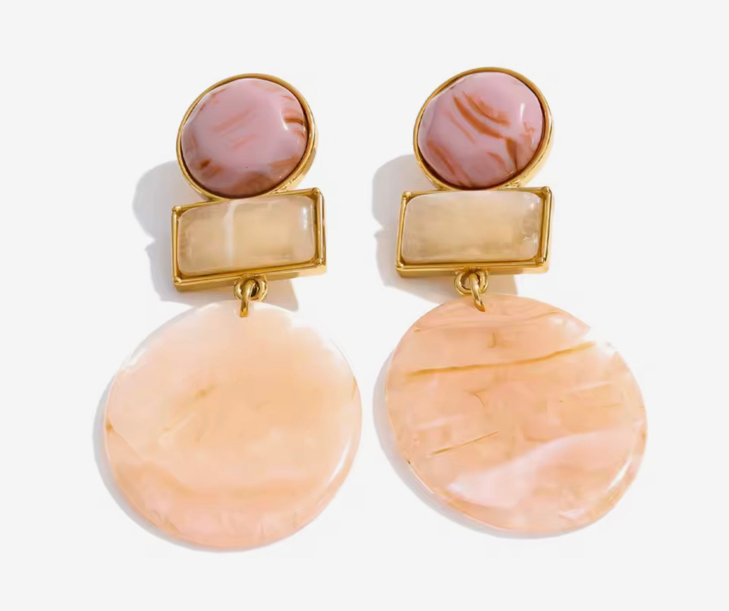Orecchini pendenti effetto marmorizzato nei toni pastello.
Eleganti ma con un tocco creativo, questi orecchini uniscono forme geometriche e nuance calde per un risultato super raffinato. Le diverse texture effetto marmo creano profondità e movimento, perfette per illuminare il viso con delicatezza