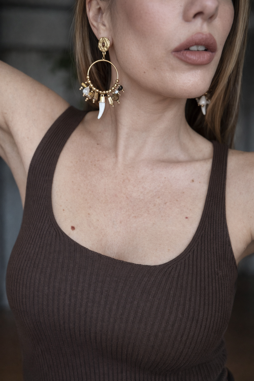 Orecchini a cerchio con charms e dettagli naturali.
Un modello ricco e super scenografico, pensato per chi ama accessori che fanno davvero la differenza. La struttura a cerchio è arricchita da piccoli charms e perline nelle tonalità calde, con un delicato pendente effetto corno che dona carattere e originalità.

Perfetti per dare movimento e personalità anche ai look più semplici, dal giorno alla sera